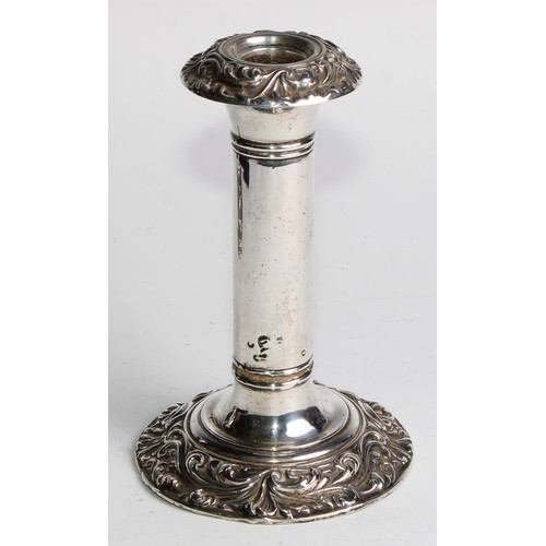 1016 - A pair of Edwardian silver candlesticks, leafy scroll borders, 16cm high, Birmingham 1906