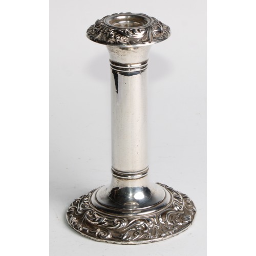 1016 - A pair of Edwardian silver candlesticks, leafy scroll borders, 16cm high, Birmingham 1906