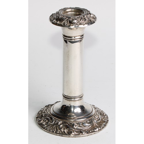 1016 - A pair of Edwardian silver candlesticks, leafy scroll borders, 16cm high, Birmingham 1906