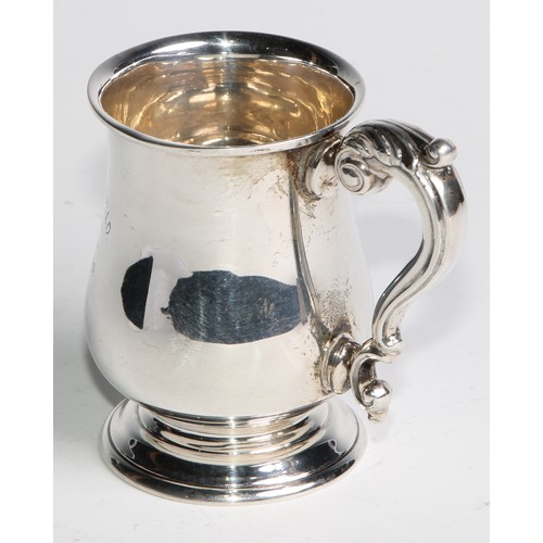 957 - A George V silver bell shaped Christening  mug, of George III design, acanthus capped double scroll ... 