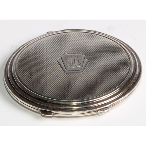 1128 - An Art Deco silver powder compact, hinged cover engraved with a geometric lozenge on an engine turne... 