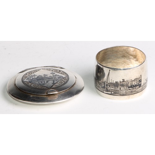 1189 - An Iraqi silver and niello circular compact,  hinged cover decorated with a desert scene, to verso w... 