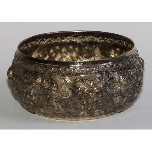 850 - A 19th century Burmese silver circular bowl, repousse chased with deities and scrolling foliage, gil... 