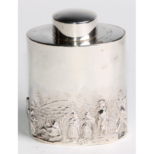 1003 - A late Victorian/Edwardian silver oval tea caddy, chased in the manner of Teniers with figures revel... 