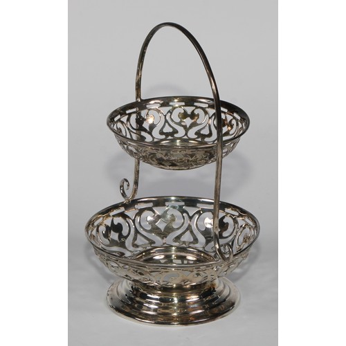 979 - A George V silver two-tier sweetmeat waiter, pierced with scrolls, arched handle, stepped circular b... 