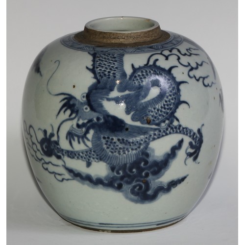 393 - A Chinese ovoid ginger jar, painted in tones of underglaze blue with a dragons chasing flaming pearl... 