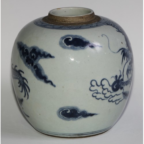 393 - A Chinese ovoid ginger jar, painted in tones of underglaze blue with a dragons chasing flaming pearl... 