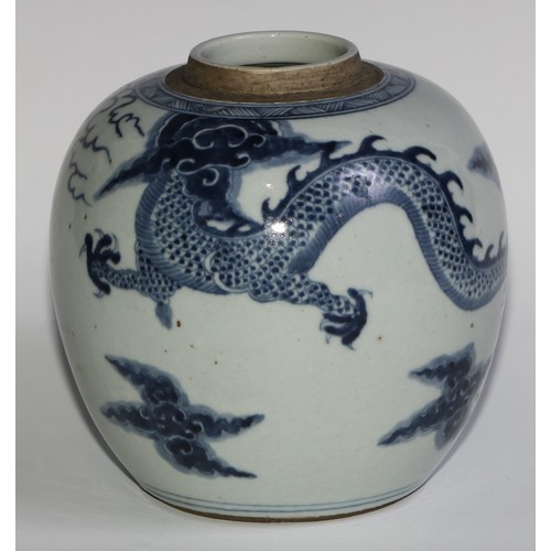 393 - A Chinese ovoid ginger jar, painted in tones of underglaze blue with a dragons chasing flaming pearl... 