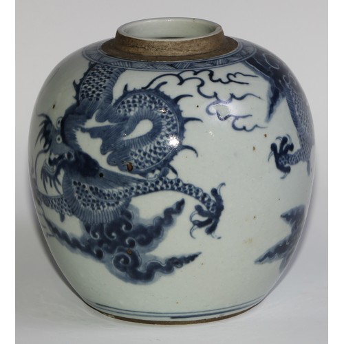 393 - A Chinese ovoid ginger jar, painted in tones of underglaze blue with a dragons chasing flaming pearl... 