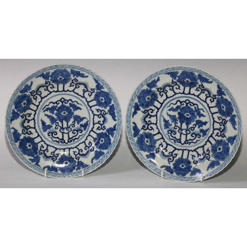 470 - A pair of Chinese shaped circular dishes, painted in tones of underglaze blue with flowers and scrol... 