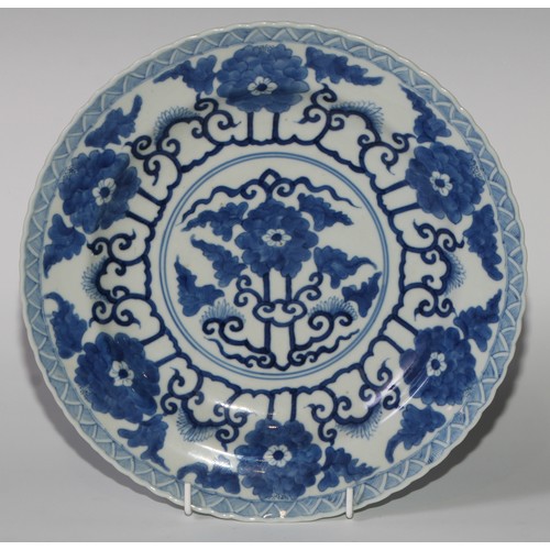 470 - A pair of Chinese shaped circular dishes, painted in tones of underglaze blue with flowers and scrol... 