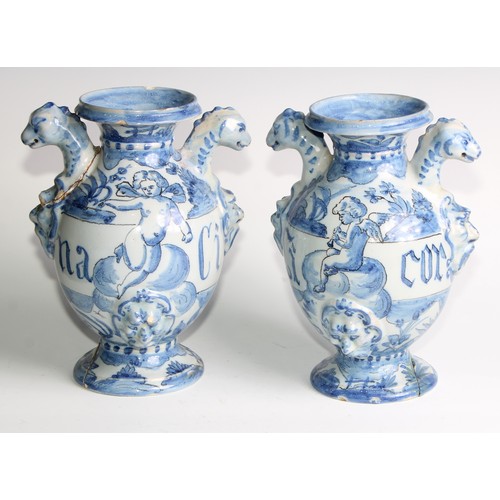 97 - A pair of Delft apothecary drug jars, each inscribed and painted in tones of blue with putti in a la... 