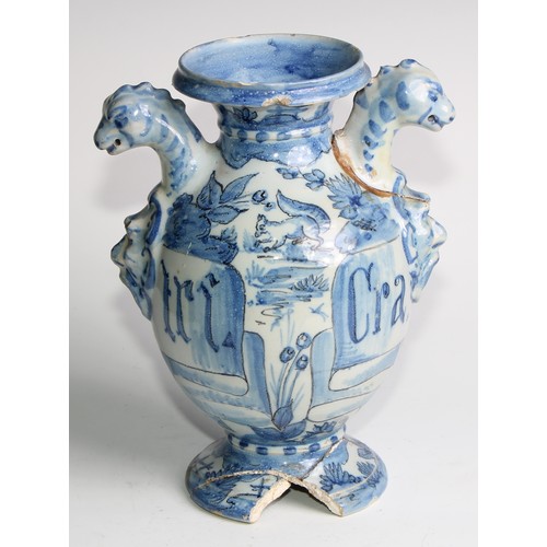 97 - A pair of Delft apothecary drug jars, each inscribed and painted in tones of blue with putti in a la... 