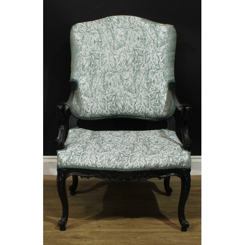 1975 - A pair of Louis XV Revival ebonised fauteuils, each with stuffed-over upholstery, shaped arms carved... 