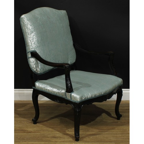 1975 - A pair of Louis XV Revival ebonised fauteuils, each with stuffed-over upholstery, shaped arms carved... 