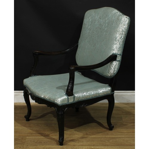 1975 - A pair of Louis XV Revival ebonised fauteuils, each with stuffed-over upholstery, shaped arms carved... 