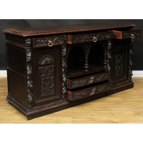 1608 - A 19th century historicist oak low dog-kennel dresser or side cabinet, rectangular top with lunette ... 