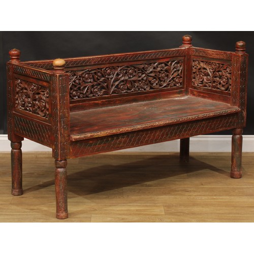 1970 - A mid-20th century Javanese stained and parcel-painted plantation bench, the back and sides pierced ... 