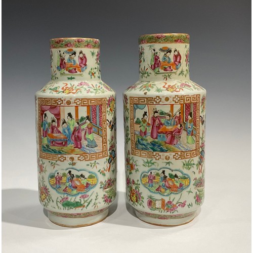 452 - A pair of Cantonese Famille Rose cylindrical vases, decorated with alternating shaped panels of Orie... 