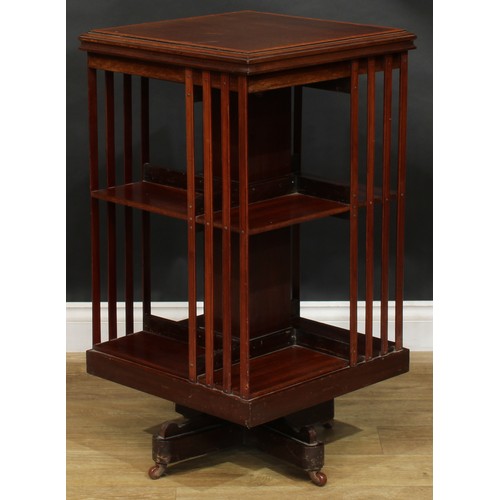 1880 - An Edwardian mahogany revolving bookcase, satinwood crossbanded square top above an arrangement of o... 