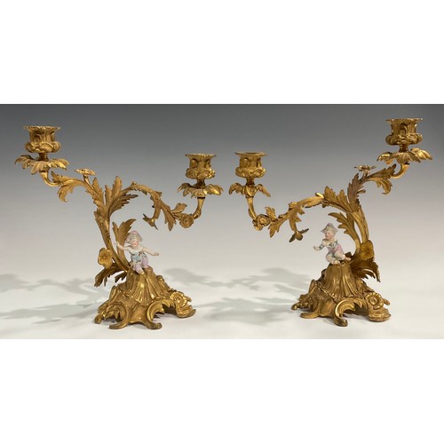 2094 - A pair of Rococo Revival gilt metal two-light candelabra, each cast with flowers and scrolling acant... 