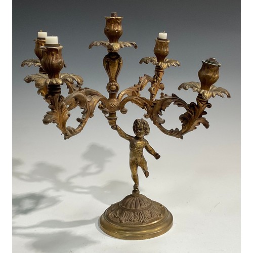 2093 - A pair of Rococo Revival gilt metal five light candelabra, each cast as a scantily clad putto holdin... 