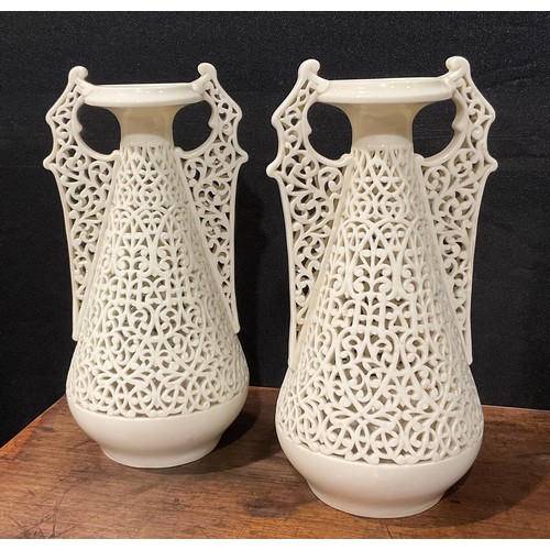 183 - A pair of Graingers Worcester reticulated spreading ovoid vases, in the white, with Persian inspired... 