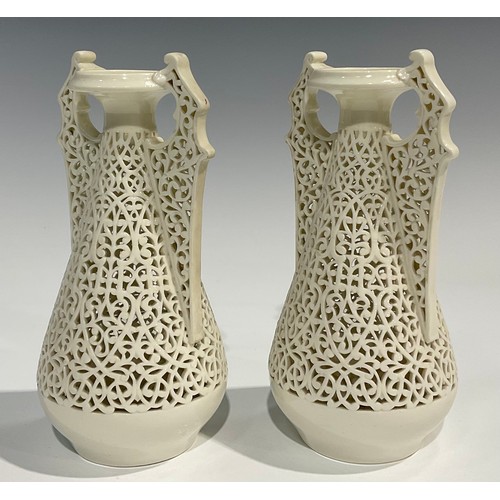 183 - A pair of Graingers Worcester reticulated spreading ovoid vases, in the white, with Persian inspired... 