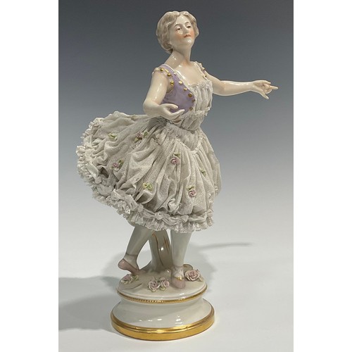 293 - A German Volkstedt porcelain figure of a ballerina,   wearing a lace porcelain skirt encrusted with ... 