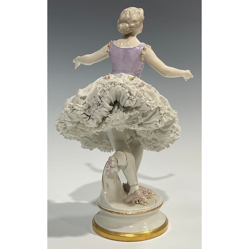 293 - A German Volkstedt porcelain figure of a ballerina,   wearing a lace porcelain skirt encrusted with ... 