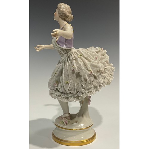 293 - A German Volkstedt porcelain figure of a ballerina,   wearing a lace porcelain skirt encrusted with ... 