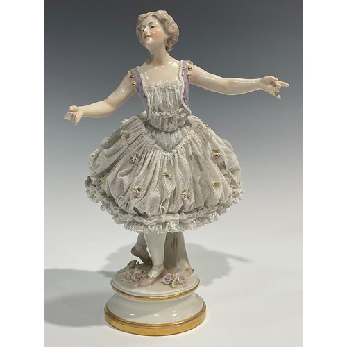 293 - A German Volkstedt porcelain figure of a ballerina,   wearing a lace porcelain skirt encrusted with ... 