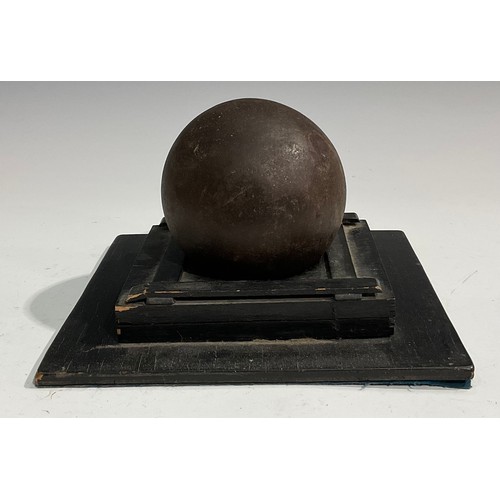 1558 - A 19th century cast iron cannonball, the collector’s stand with label inscribed Russian round shot r... 