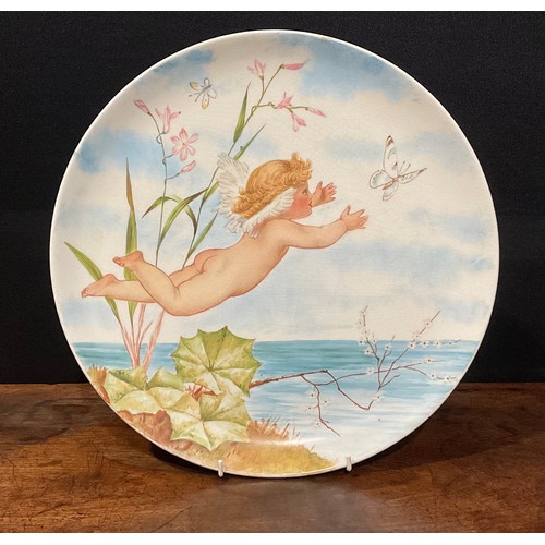 78 - An Aesthetic Movement circular charger, painted with cherub chasing butterflies above a tranquil pon... 