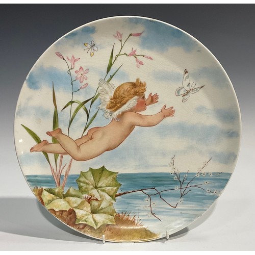 78 - An Aesthetic Movement circular charger, painted with cherub chasing butterflies above a tranquil pon... 