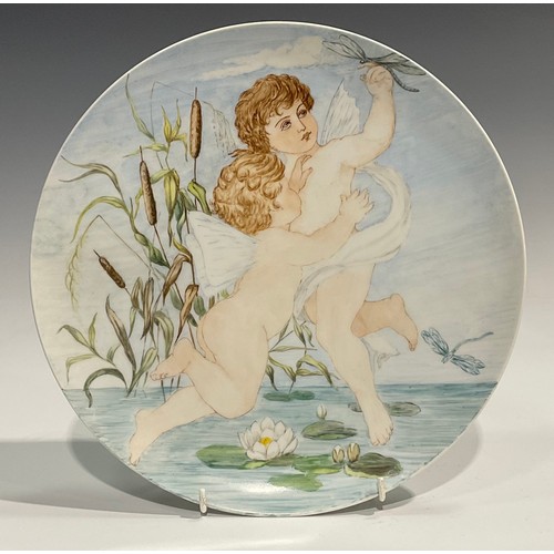 67 - An Aesthetic Movement Berlin porcelain circular charger, painted with two cherubs above a lilypond w... 