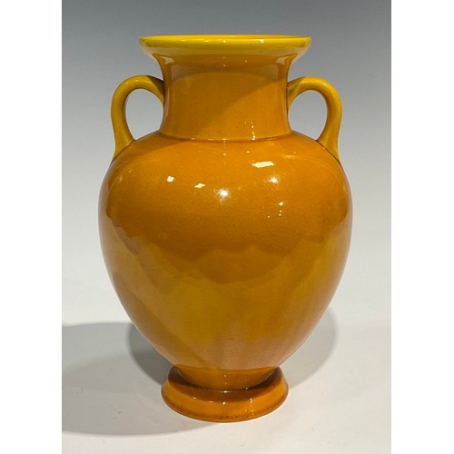 43 - A Burmantofts Faience two handled amphora shaped vase, glazed throughout in yellow, 23cm high, shape... 