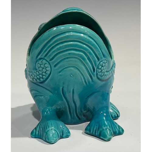 39 - A Burmantofts Faience spoon warmer, as a grotesque seated toad, glazed throughout turquoise, 12.5cm ... 