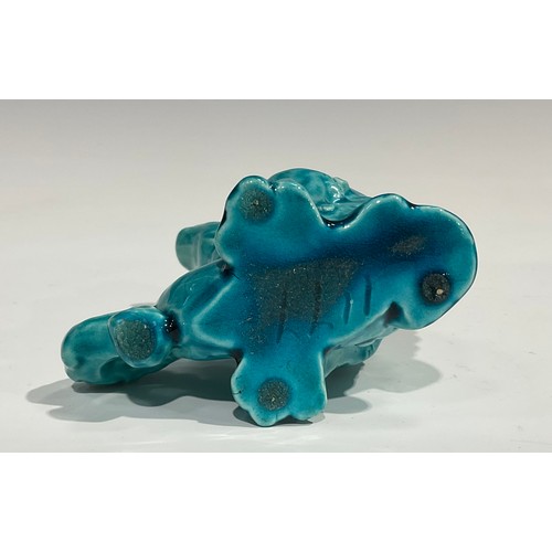 59 - A pair of Burmantofts Faience models, of dragon type mythical beasts, glazed throughout in turquoise... 