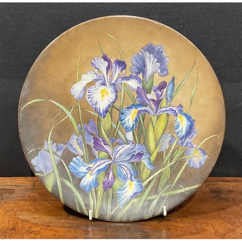 79 - An Aesthetic Movement circular charger, painted with purple irises, 31cm diameter, paper labels to v... 