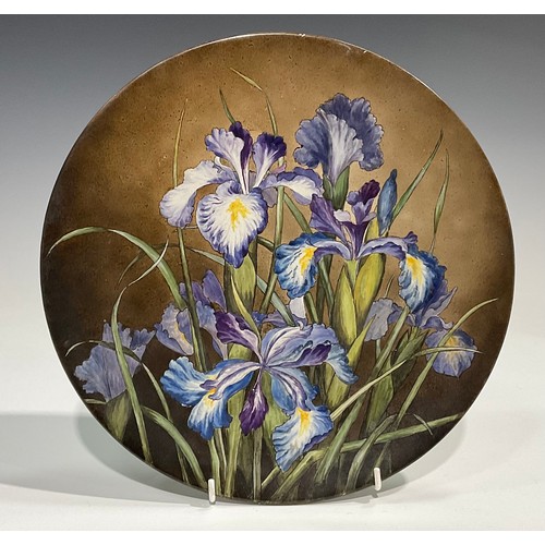 79 - An Aesthetic Movement circular charger, painted with purple irises, 31cm diameter, paper labels to v... 