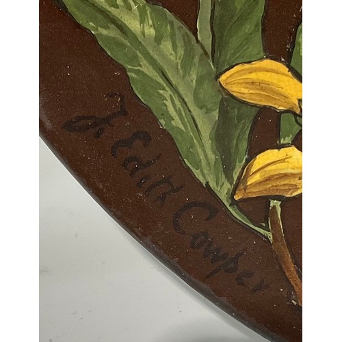 74 - An Aesthetic Movement circular charger, painted by J Edith Cowper, signed, with yellow alstroemerias... 