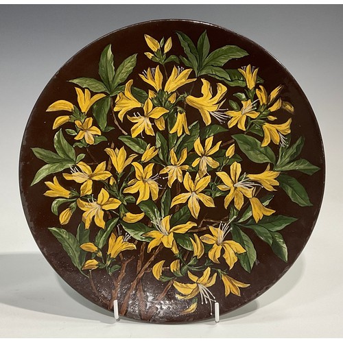 74 - An Aesthetic Movement circular charger, painted by J Edith Cowper, signed, with yellow alstroemerias... 