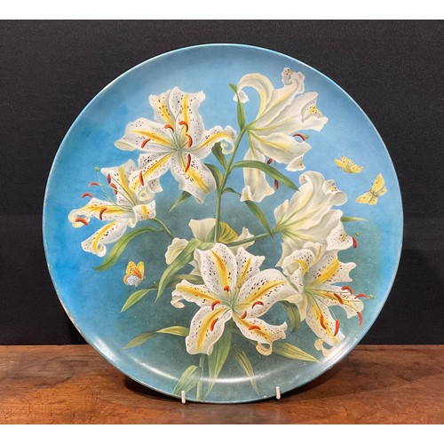 75 - An Aesthetic Movement circular charger, painted by M S Williams, with lilies on an ombre blue ground... 