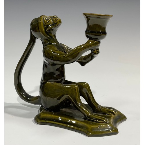 45 - A Burmantofts style spoon warmer, as a grotesque seated toad, glazed throughout olive green, 13cm hi... 