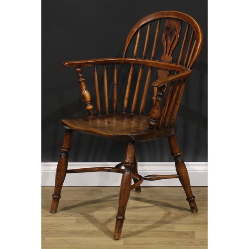 1852 - A near pair of 19th century yew and elm Windsor elbow chairs, each with a low hoop back, shaped and ... 