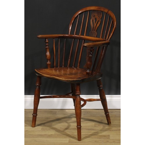 1852 - A near pair of 19th century yew and elm Windsor elbow chairs, each with a low hoop back, shaped and ... 