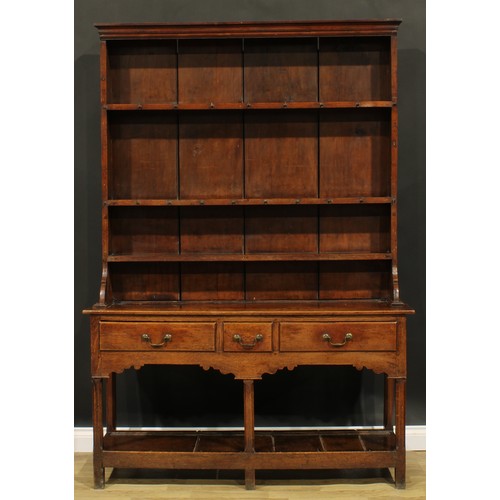 2119 - A George III oak potboard dresser, moulded cornice above three plate rack shelves, the projecting ba... 