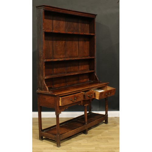 2119 - A George III oak potboard dresser, moulded cornice above three plate rack shelves, the projecting ba... 