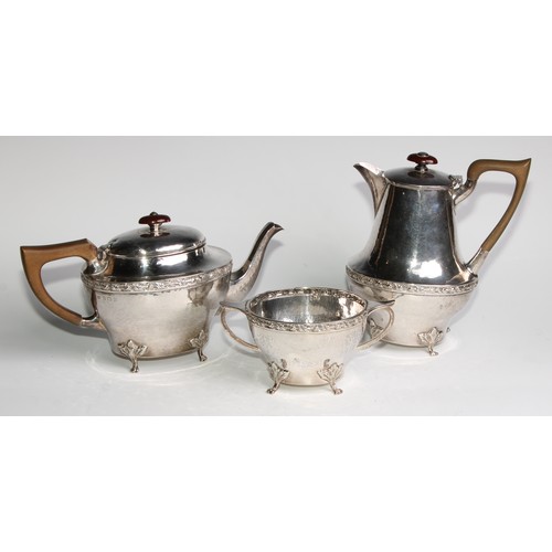 1139 - An Arts and Crafts silver three piece tea service, comprising teapot, hot water pot and sugar basin,... 